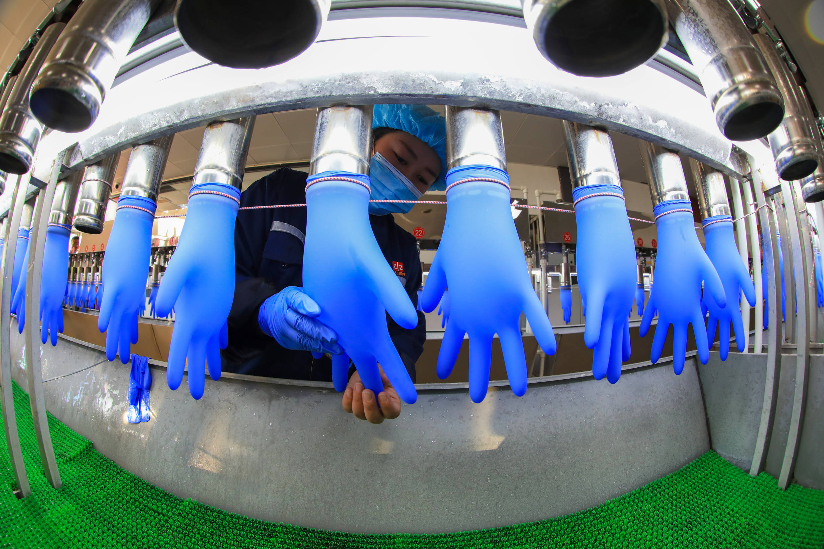 Worker inspecting nitrile gloves for defects